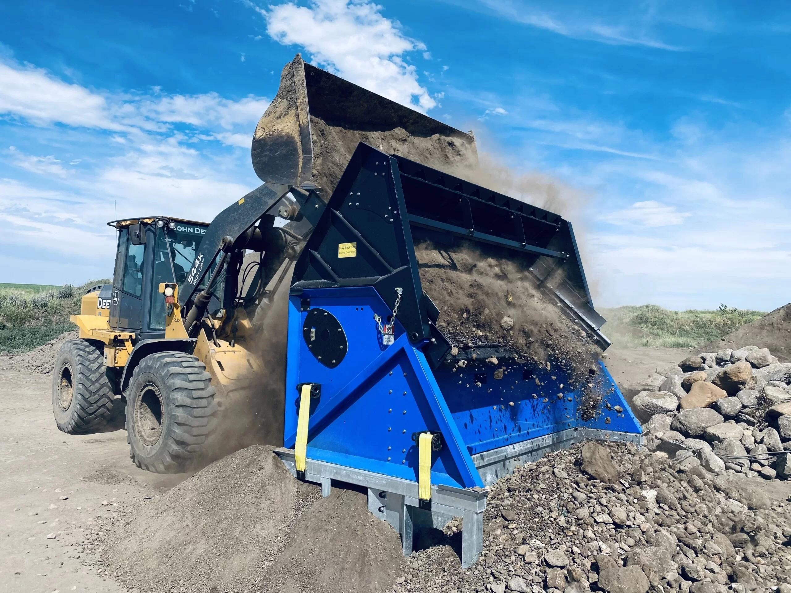 topsoil screener onsite feed with large bucket tractor